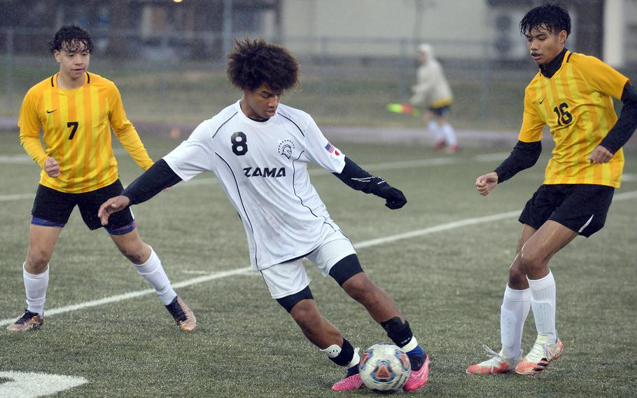 Zama's Jaydn Parker tries to settle the ball against Robert D. Edgren's Axel Nogueras and Bryce Dries during Friday's Japan boys soccer friendly match. The Trojans won 8-0. 