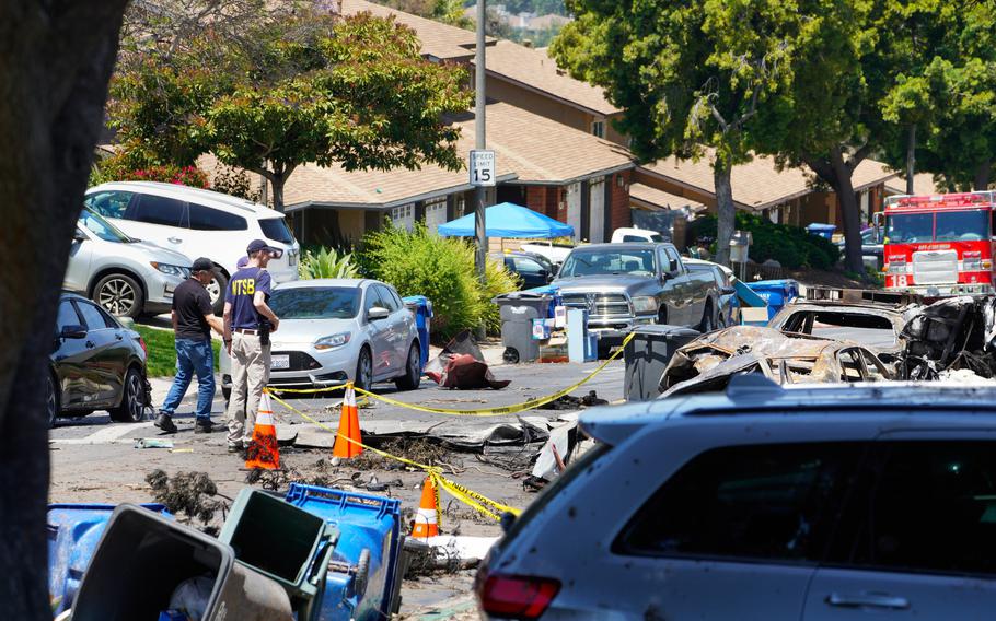 A street with do-not-cross tape blocking off a damaged area.