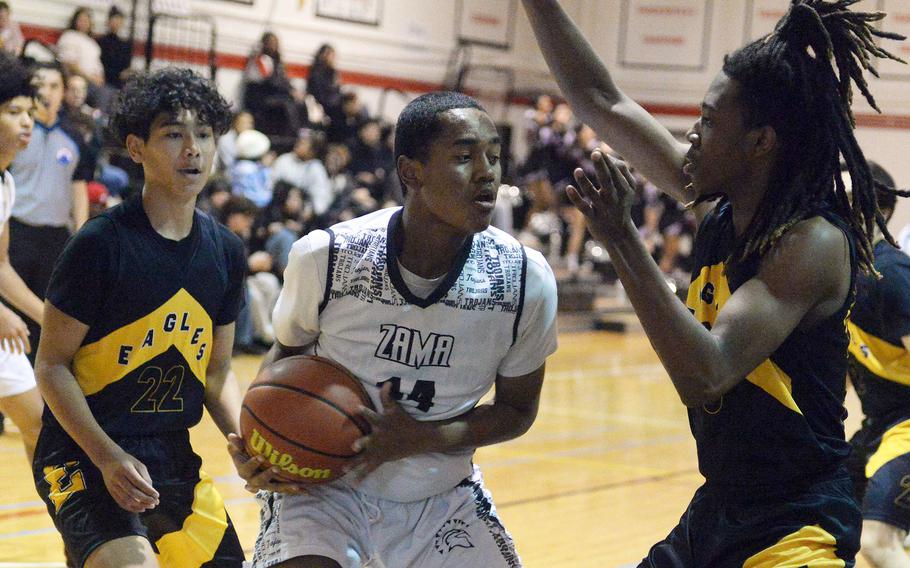 Zama's Derek Smith gets sandwiched by Robert D. Edgren's Tsutomu Gordon and JeShawn Spaights-Pace during Friday's DODEA-Japan boys basketball game. The Trojans won 61-37.