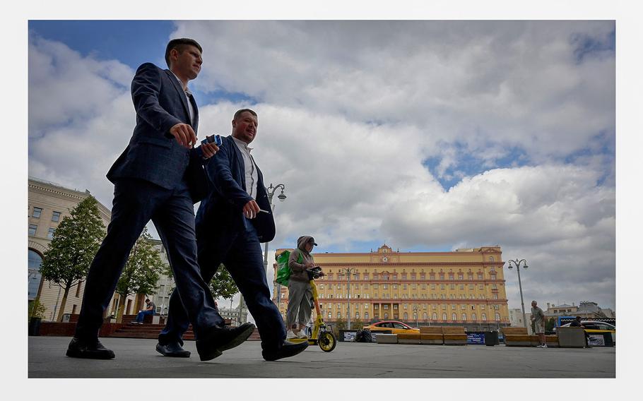 Men walk in front of the headquarters of Russia's Federal Security Services in central Moscow on Aug. 28, 2023. 