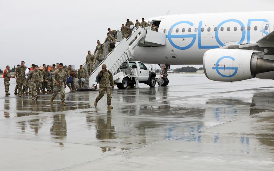 Alaska Army Guard Capt. Richard Collins, commander of Bravo Company, 1st Battalion, 297th Infantry Regiment, leads his troops on to the flight line at Joint Base Elmendorf-Richardson, Alaska, Aug. 10, 2024, after a nine-month deployment to Kuwait. 