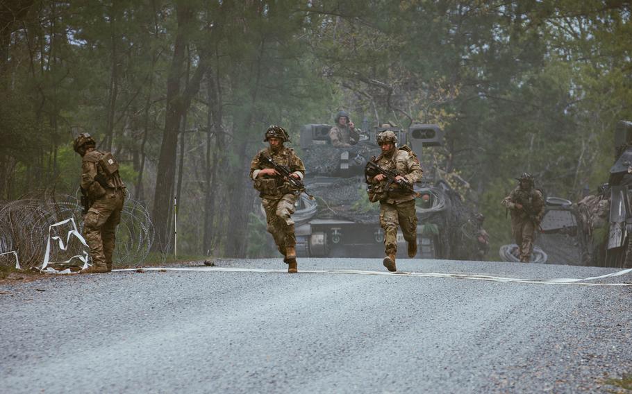 Soldiers breach a razor wire barrier during a training exercise at Fort Johnson, La., on March 20, 2024.