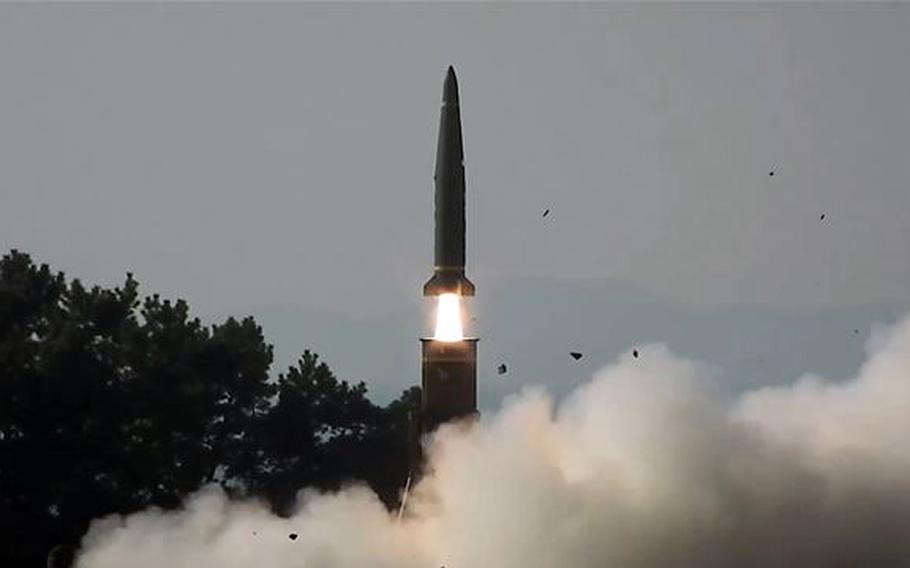 A ballistic missile, seen from a distance, is fired into the sky.