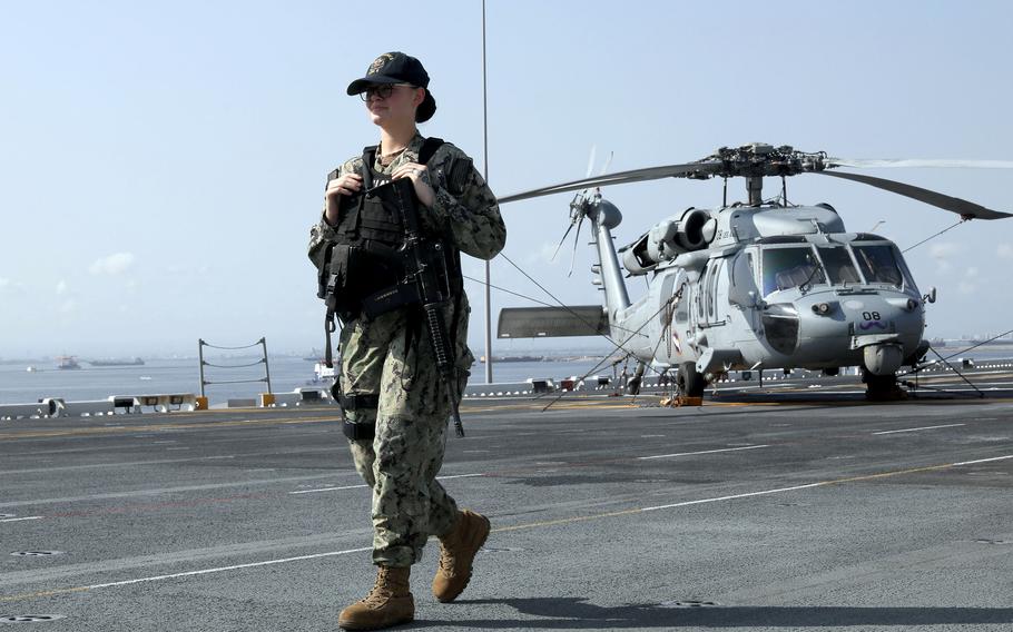 A sailor walks on the deck of the amphibious assault ship USS America while docked at Manila's South Harbor, Tuesday, March 21, 2023.