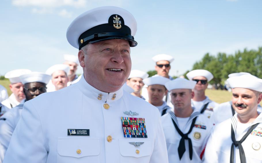 A uniformed sailor smiles.
