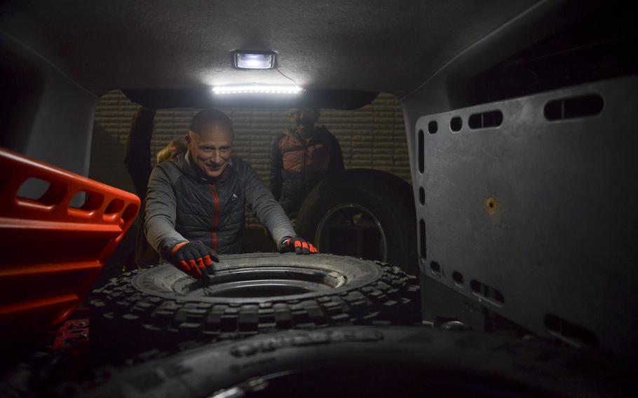 Wojtek Bauman, a volunteer for the Polish charity Be a Hero UA, loads extra off-road tires into a vehicle bound for war-ravaged eastern provinces in Ukraine, at a warehouse on the outskirts of Warsaw, Poland on Nov. 4, 2022. 