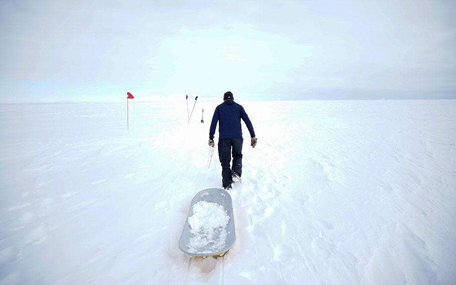 Camp manager Troy Nave gathers snow that he will melt into water for drinking and washing. 