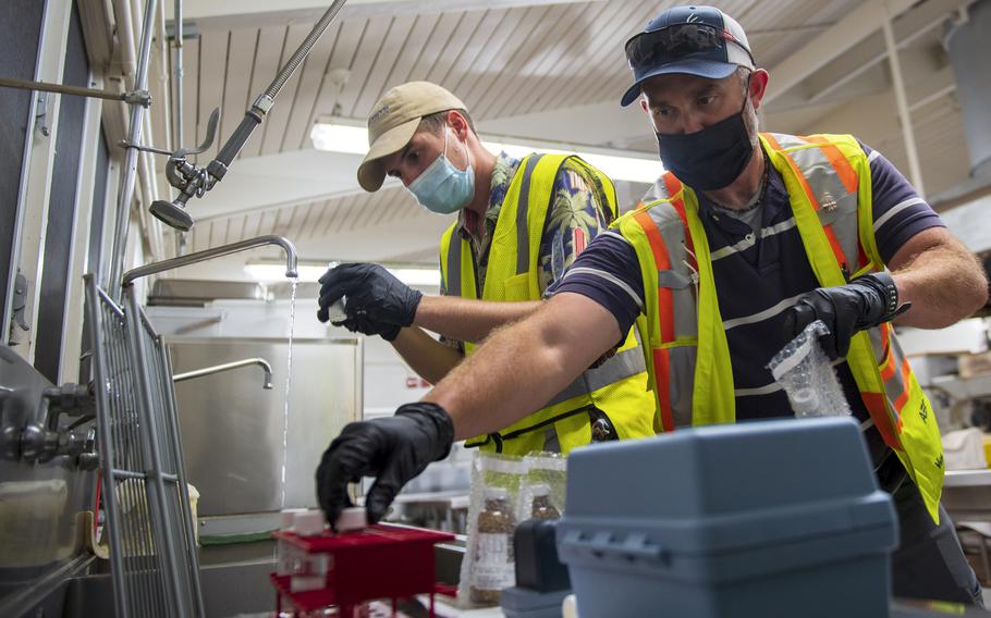 Contractors with Naval Facilities Engineering Systems Command collect water samples at Red Hill Elementary School in Aiea, Hawaii, March 11, 2022, as part of long-term monitoring of drinking water from the Navy’s water system that was contaminated by jet fuel.