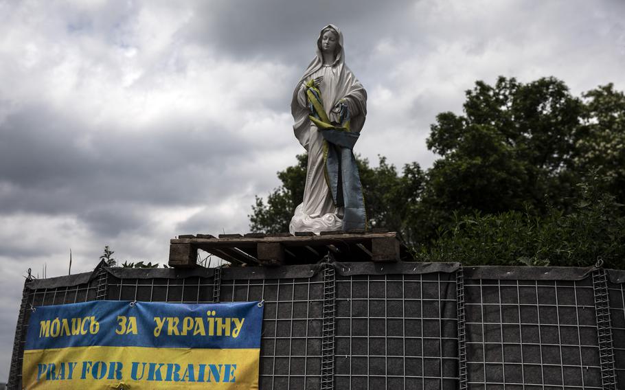 On the road between Dnipro and Pokrovsk a statue of the Virgin Mary wearing the Ukrainian national flag is seen at a military post on May 28, 2022.