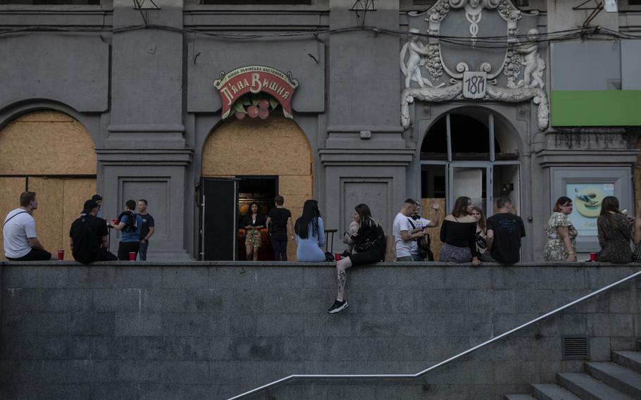 Young Ukrainians drinking outside the Piana Vyshnia, or Drunk Cherry, a Ukrainian chain specializing in sweet cherry liquor in Kharkiv, Ukraine on Aug. 11, 2022. 