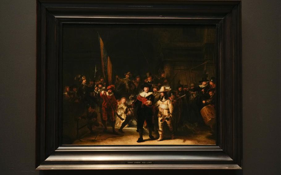 A copy of the Night Watch attributed to painter Gerrit Lundens served as the basis for artificial intelligence allowing Rembrandt's biggest painting the Night Watch to get bigger, is displayed next to the painting in Amsterdam, Netherlands, Wednesday, June 23, 2021. The Dutch national museum and art gallery reveals findings from a long-term project to examine in minute detail Rembrandt van Rijn's masterpiece the Night Watch.