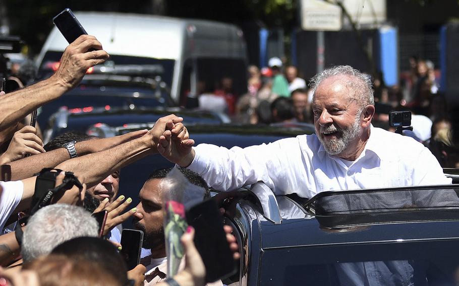 Former Brazilian President and candidate for the leftist Workers Party Luiz Inacio Lula da Silva greets supporters while leaving the polling station, during the presidential run-off election, in Sao Paulo, Brazil, on October 30, 2022. 