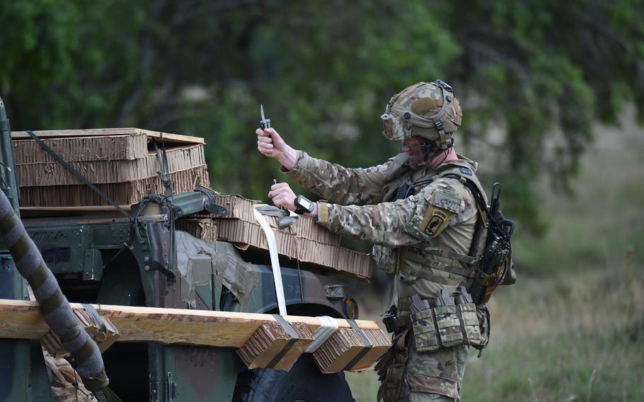 A soldier with the 173rd Airborne Brigade unpacks and assembles an M119A3 howitzer and a tactical vehicle after they were dropped by parachute from a C-130 aircraft at the Hohenfels training area in Germany, Sept. 8, 2022. 