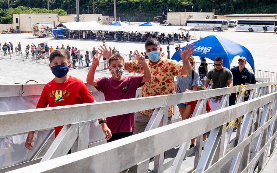 Masked visitors are escorted aboard the aircraft carrier USS Carl Vinson for a tour during a port visit to Naval Base Guam, Nov. 13, 2021.