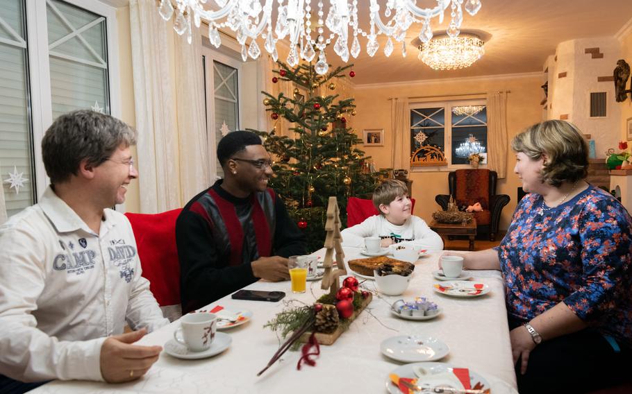 Alexander Schweitzer, left, Army Spc. Lamar Porter, Silas Schweitzer and Tina Schweitzer enjoy cake and coffee on Christmas Day 2023. The Schweitzers hosted Porter for the holiday as part of Operation Good Cheer.