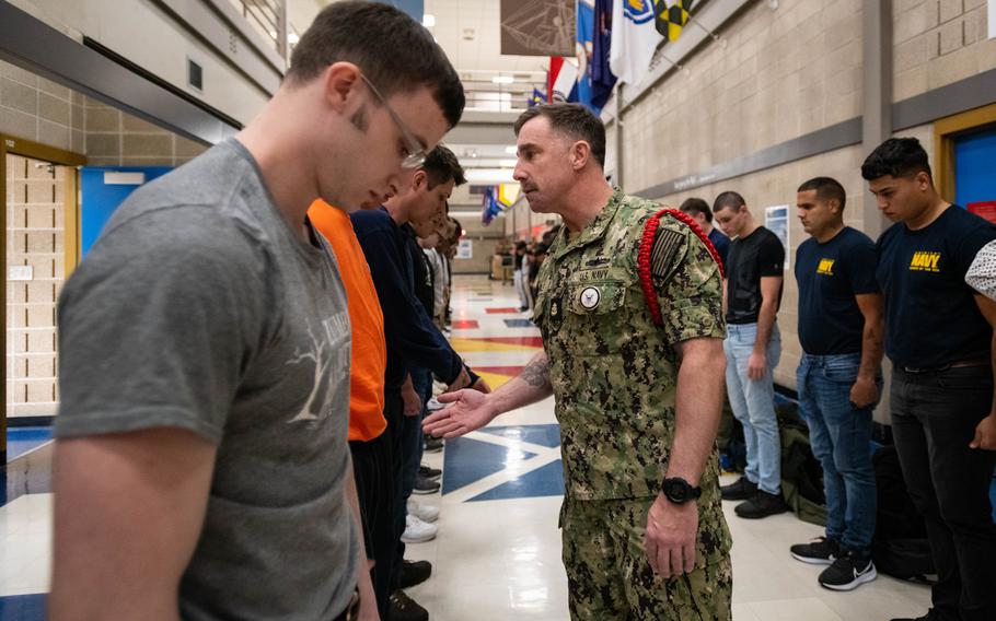 A staff member motivates new Navy recruits on April 19, 2023, as they line up inside the in-processing center at the service’s Recruit Training Command at Naval Station Great Lakes, Ill. Boot camp is approximately 10 weeks and all enlistees into the Navy begin their careers at the command. More than 40,000 recruits train annually at the Navy’s only boot camp.