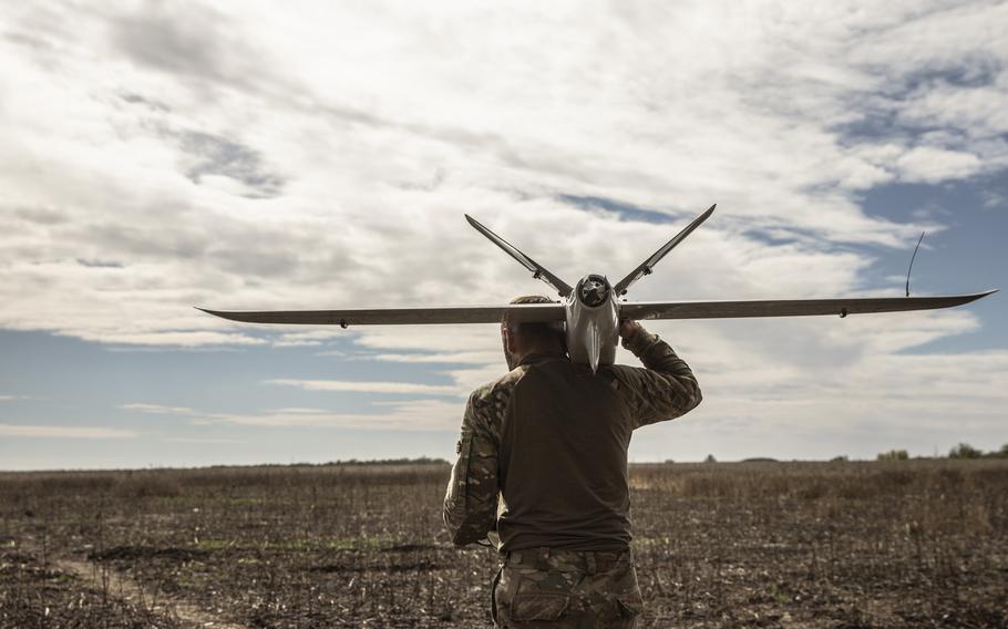 A Ukrainian soldier who goes by the call name “Viter” carries a Leleka-100 drone about to be launched, and carefully navigates his way through a field on Thursday in the Kherson region, Ukraine, seeded with Russian mines. 