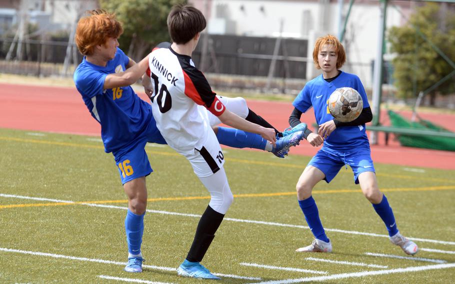 Yokota's Alex Kosinski (16) reaches in to  boot the ball away from Nile C. Kinnick's Ryo Nishyama and out of bounds as Panthers teammate Tommy Vogeley watches during the championship match in the Perry Cup soccer tournament. The Red Devils shut out the Panthers 2-0.