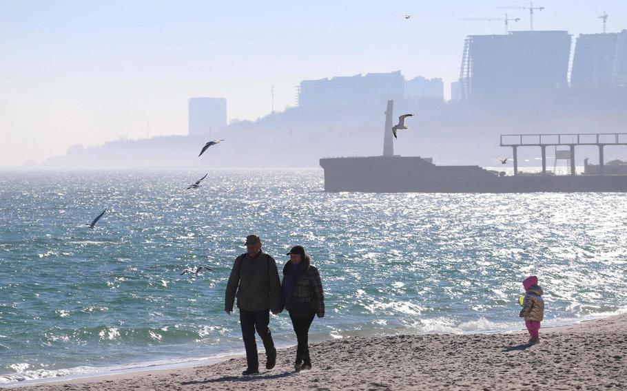 People walk on a beach in Ukrainian Black Sea city of Odessa on February 21, 2022. - NATO chief Jens Stoltenberg on February 21, 2022, condemned Russian President Vladimir Putin's recognition of rebel-held areas in east Ukraine, saying it violated international agreements Moscow had signed. 