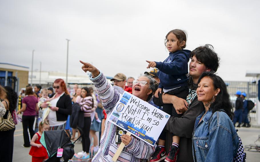 Families hold signs and point ahead