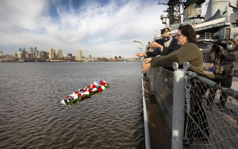 A memorial wreath is tossed into the Delaware River from the Battleship New Jersey by Bernie Kofoet, left, a member of the American Legion FW Grigg Post #68, and Camden Commissioner Melinda Kane as part of a Pearl Harbor Day Commemoration.