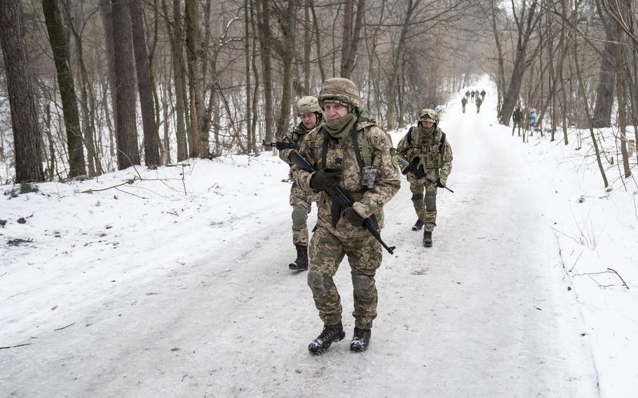 Volunteers with the Ukrainian Territorial Defense Forces traverse an ice-covered road outside of Kyiv in early February 2022, weeks before Russia's invasion. With the onset of winter drawing near, observers see the war entering another tough new phase. 