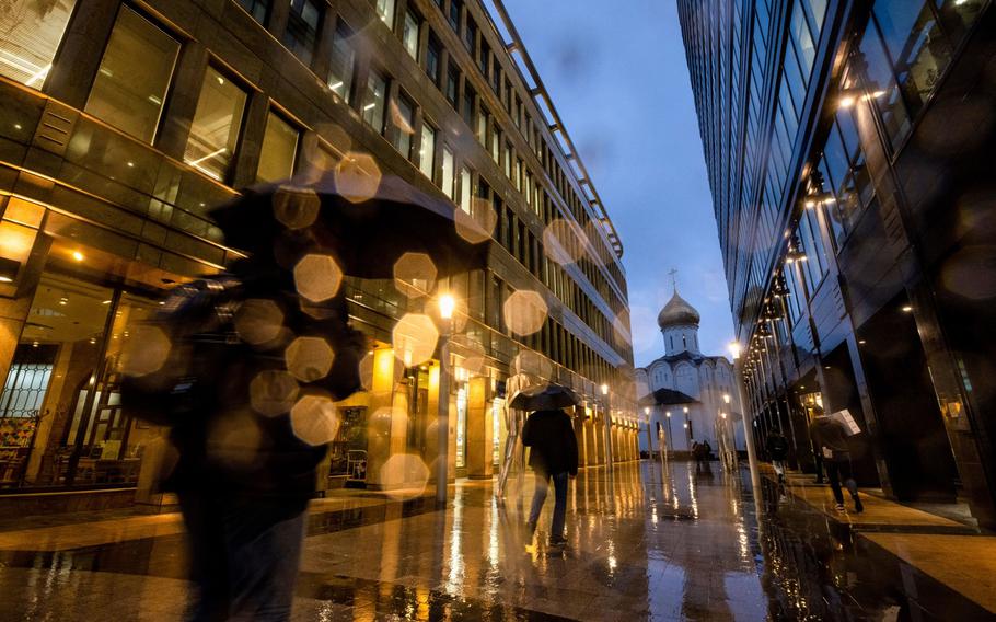 Pedestrians walk through a plaza in the rain in Moscow on Oct. 28. MUST CREDIT: Bloomberg photo by Andrey Rudakov