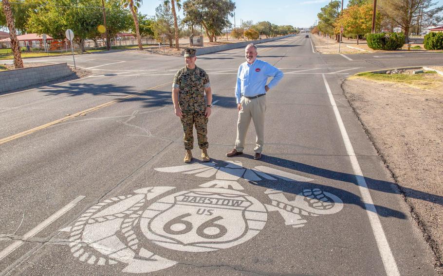Marine Corps Maj. Gen. Joseph F. Shrader, the commanding general of Marine Corps Logistics Command, and David R. Clifton, the command’s executive deputy, stand at the Route 66 Eagle, Globe and Anchor pavement marking at Marine Corps Logistics Base Barstow, Calif., on Oct. 22, 2021. Officials dedicated a new monument near the marker Nov. 9.