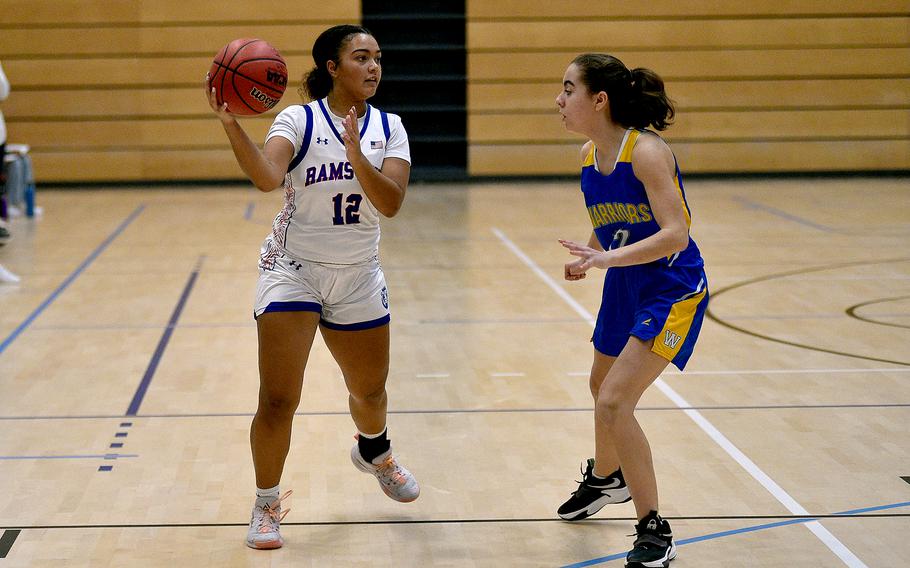 Ramstein junior Parker Ingram passes against Wiesbaden junior Angelica Shea during pool-play action of the DODEA European basketball championships on Feb.14, 2024, at the Wiesbaden Sports and Fitness Center on Clay Kaserne in Wiesbaden, Germany.