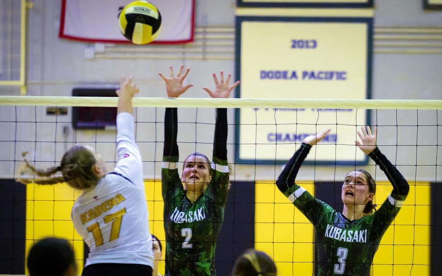 Kadena's Gabby Money spikes against Kubasaki's Grace Berrens and Adria Lockhart during Tuesday's Okinawa volleyball match. The Dragons won in three sets to seal their 18th straight island championship.