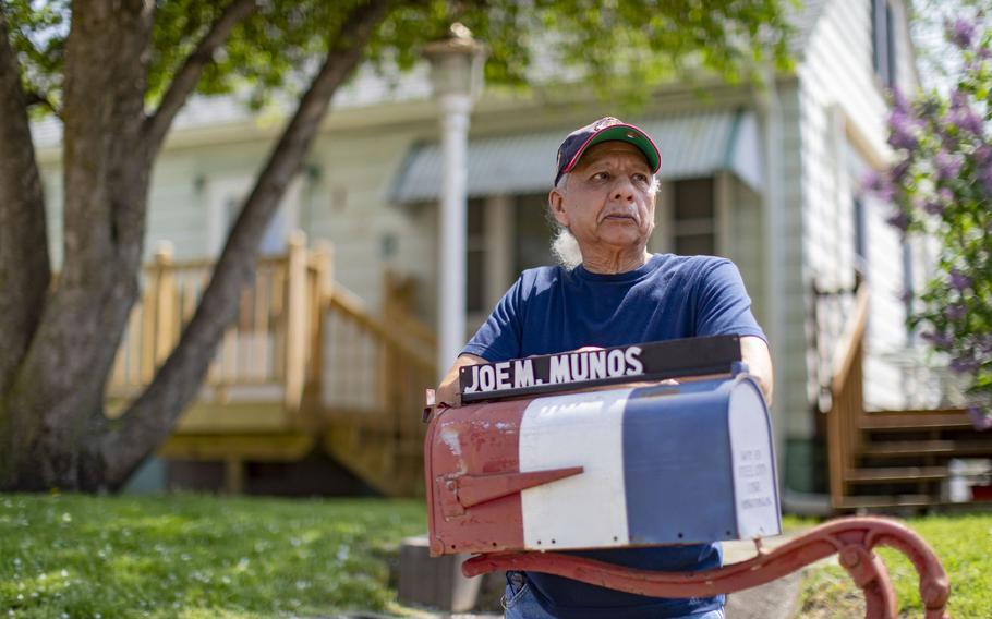 Richard Munos stands in front of the family home marked by the name of his father, Joe, on their red, white and blue mailbox, May 11, 2022, along Hero Street in Silvis, Ill.