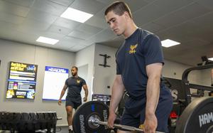 Sailors lift weights Aug. 14, 2025, during a ceremony for the opening of the upgraded gym at Naval Support Activity Souda Bay, Greece. The nearly $700,000 renovation included the addition of a zone featuring a range of strength-training equipment.