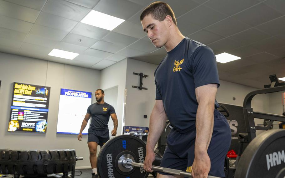 Navy sailor lifting weights in the gym.
