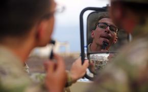 U.S. Army Soldiers with the East Africa Response Force, Task Force Associator, Combined Joint Task Force – Horn of Africa, use the mirror of a U.S. Army Humvee for an early morning shave before the start of the Bull Shark 25-1 exercise at Arta, Djibouti, on Nov. 26, 2024. The semiannual exercise brought together U.S., Djiboutian, Spanish, Japanese, and French forces to enhance communication and interoperability among international partners. It simulated complex personnel recovery scenarios across land, sea, and air domains, testing coordination and operational readiness while strengthening regional security and stability. (U.S. Air Force photo by Master Sgt. Jon Alderman)