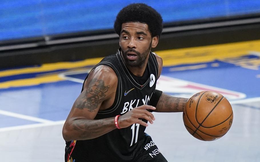 Brooklyn Nets’ Kyrie Irving moves the ball during the first half of an NBA basketball game against the Cleveland Cavaliers on May 16, 2021, in New York. Kyrie Irving will rejoin the Brooklyn Nets to play in road games. The Nets decided on Friday, Dec. 17, 2021 their point guard would practice with them and play road games, even though he remains unable to play at home because he doesn’t meet New York City’s vaccine mandate.