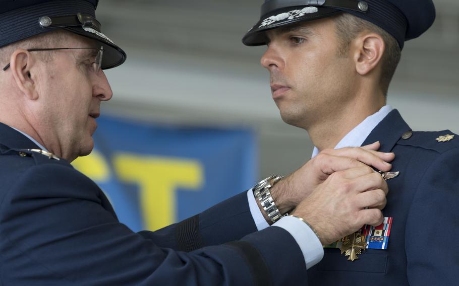 U.S. Air Force Lt. Col. Christopher McCall, 73rd Expeditionary Special Operations Squadron Shadow 71 aircraft commander, receives the Distinguished Flying Cross from Lt. Gen. Jim Slife, commander of Air Force Special Operations Command, during a ceremony at Hurlburt Field, Fla., June 22, 2021. 