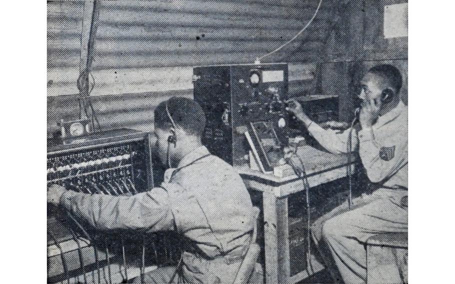 “Switchboard and radio operators work long shifts in the battery operations room, receiving information on aircraft movements in the vicinity of their battery,” read the original caption on this image, first published in the Northern Ireland edition of Stars and Stripes, Feb. 10, 1944. Two soldiers can be seen operating a switchboard and radio. 