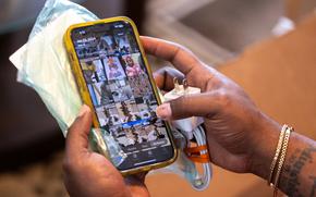 A person’s hands hold an iPhone in a yellow case.
