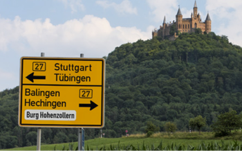 Road sign in front of hill upon which Burg Hohenzollern sits on top of