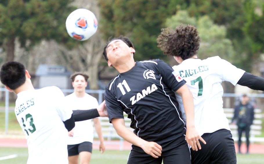 Zama’s Kaisei Muta heads the ball between Robert D. Edgren’s Brayden Reyes and Axel Nogueras during Saturday’s DODEA-Japan boys soccer match. The Trojans won 4-0.