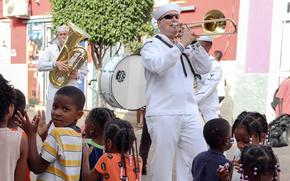 Petty officers 1st Class Luke Reed, right, and Christopher Bettler, of the Naval Forces Europe and Africa Band, march down the street at an outdoor concert May 9, 2025, in Praia, Cabo Verde, during this year's Obangame Express exercise.