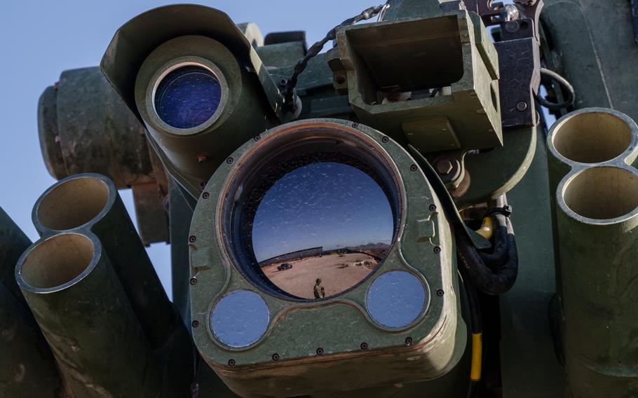 The U.S.-Mexico border wall is seen reflected in the lens of an advanced camera mounted atop an Army Stryker vehicle.