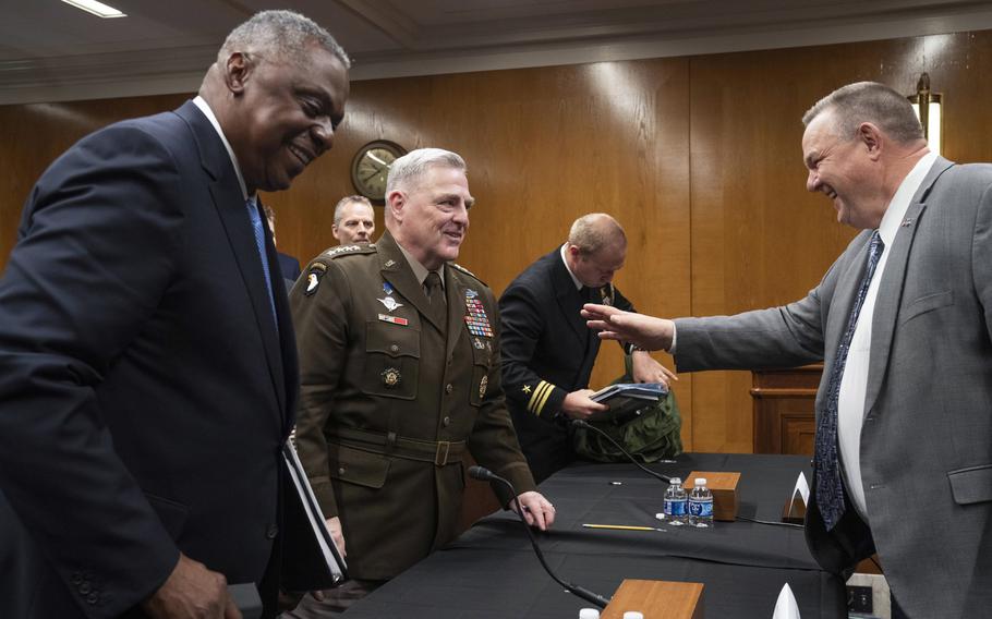 Sen. Jon Tester, D-Mont., chairman of the Senate Appropriations Committee’s subpanel on defense, right, talks Thursday, May 11, 2023, with Army Gen. Mark Milley, chairman of Joint Chiefs of Staff, center, and Defense Secretary Lloyd Austin after the two military leaders testified on Capitol Hill in Washington at a hearing on the 2024 defense budget.