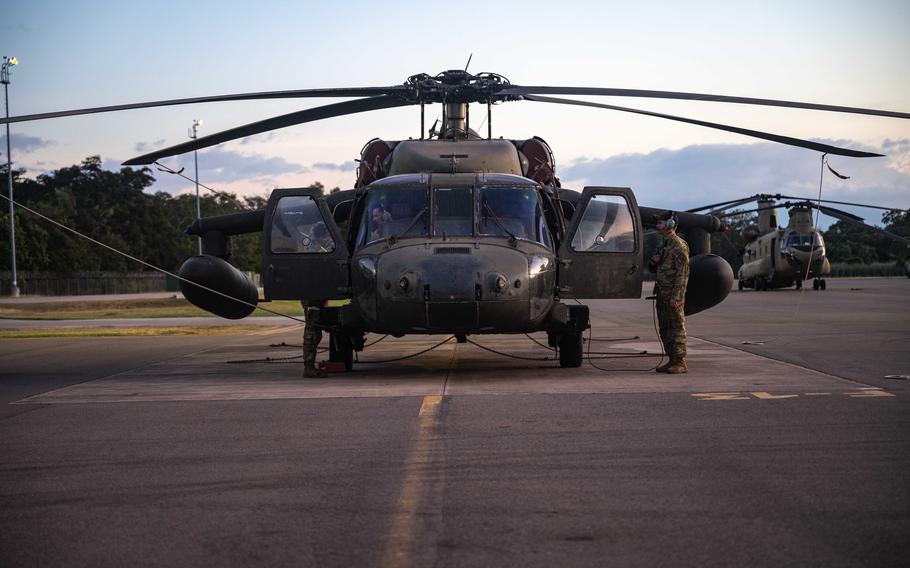 Soldiers conduct preflight inspections on a Black Hawk.