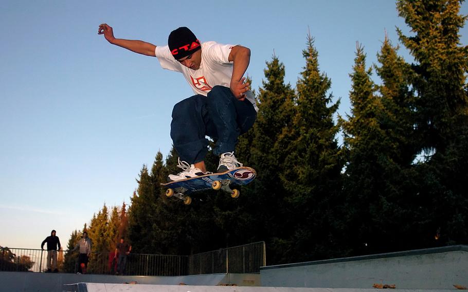 A man does a trick on a skateboard at a park