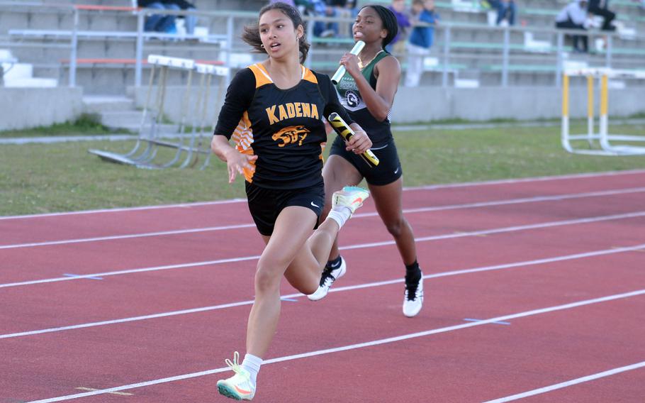 Kadena's Isabella Price leads the way toward the finish of the 400 relay ahead of Kubasaki's Peyton Wilcox during Thursday's Day 2 of the two-day Okinawa track and field meet. Kadena won in 54.47 seconds.