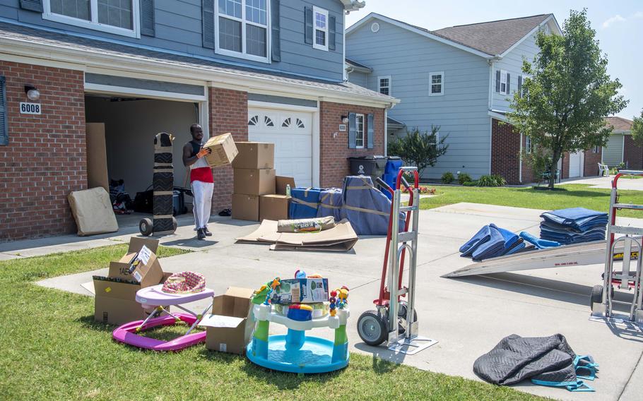 Jerry Leama, a mover with Barry Van Lines, carries a box of household goods onto a moving truck on Dover Air Force Base, Del., July 16, 2021. 