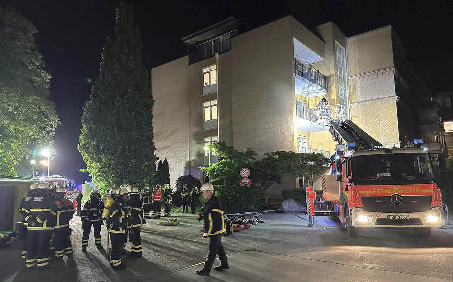 Firefighters with breathing apparatus and a ladder truck work to put out a fire at hospital.