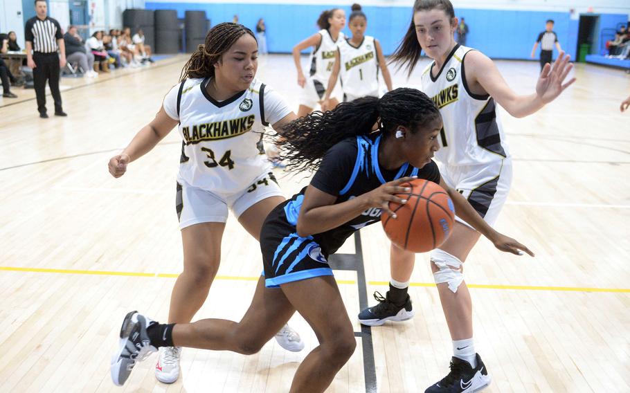 Osan's Tatiana Lunn drives past Humphreys' Nyomi Peoples and Claire Anderson during Friday's DODEA-Korea girls basketball game. The Blackhawks won the Korea inter-division battle 51-17, handing the Cougars their first loss in eight games.
