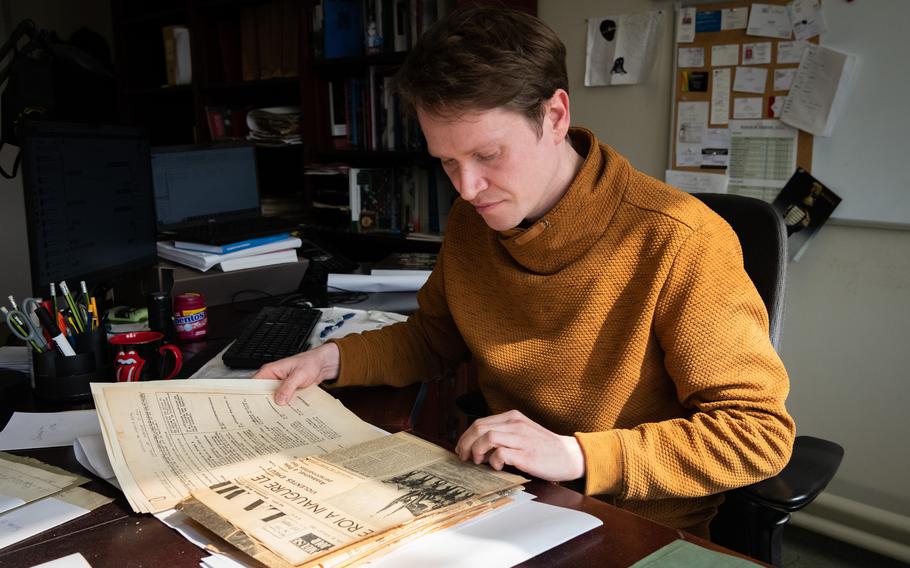 Historian Bernard Wilkin sits at his desk at Belgium’s State Archives, in Liege, Belgium, March 28, 2023. Wilkin has been a vocal critic of plans to convert the nearby Church of the Sacred Heart to an upscale restaurant and climbing facility.